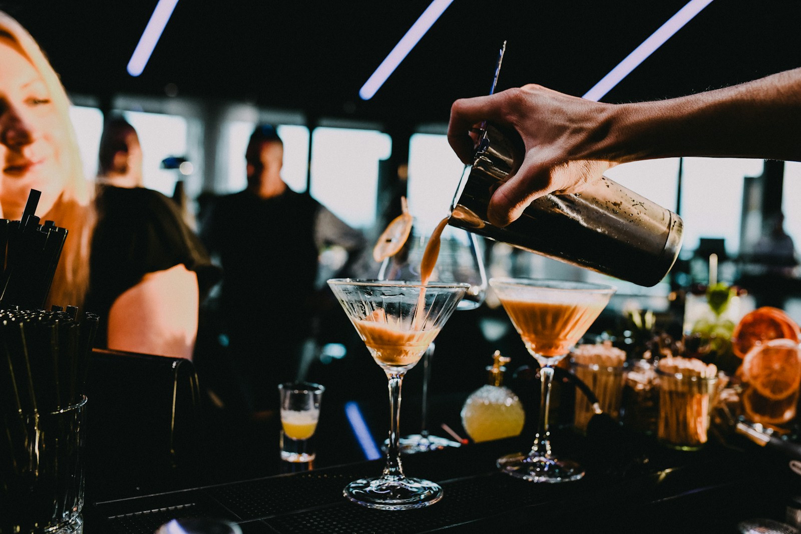 a person pouring a drink into a glass
