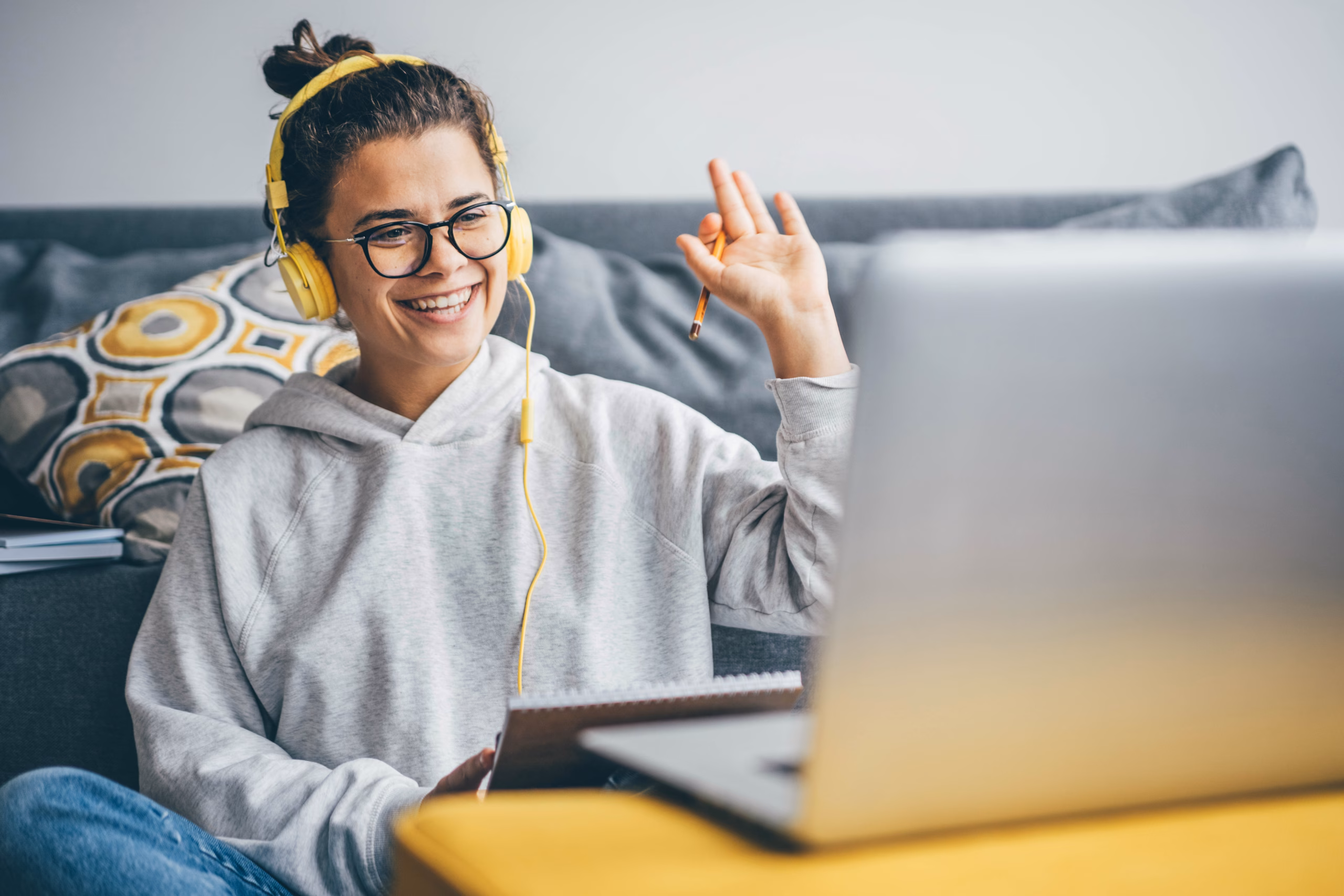 Millennial woman having video call on her computer at home. Smil Millennial woman having video call on her computer at home. Smiling girl studying online with teacher.