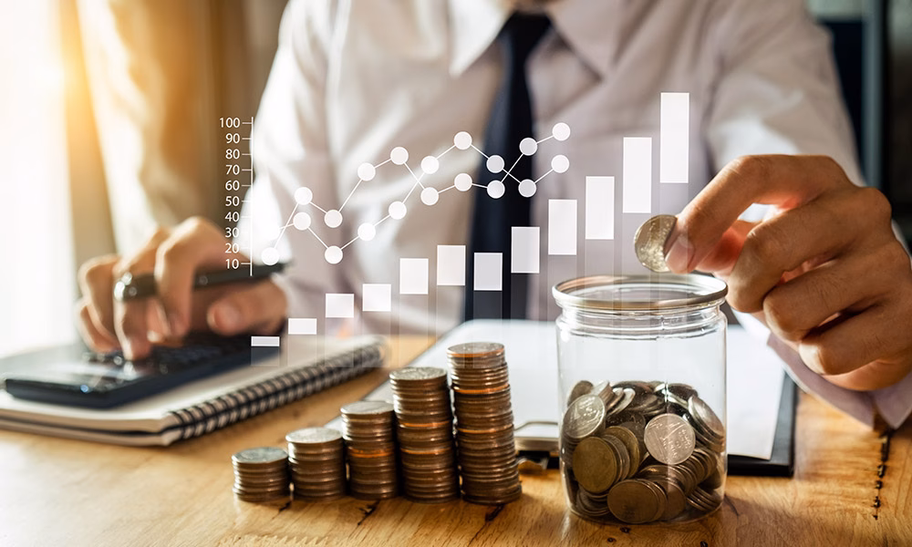 businessman holding coins putting in glass with using smartphone