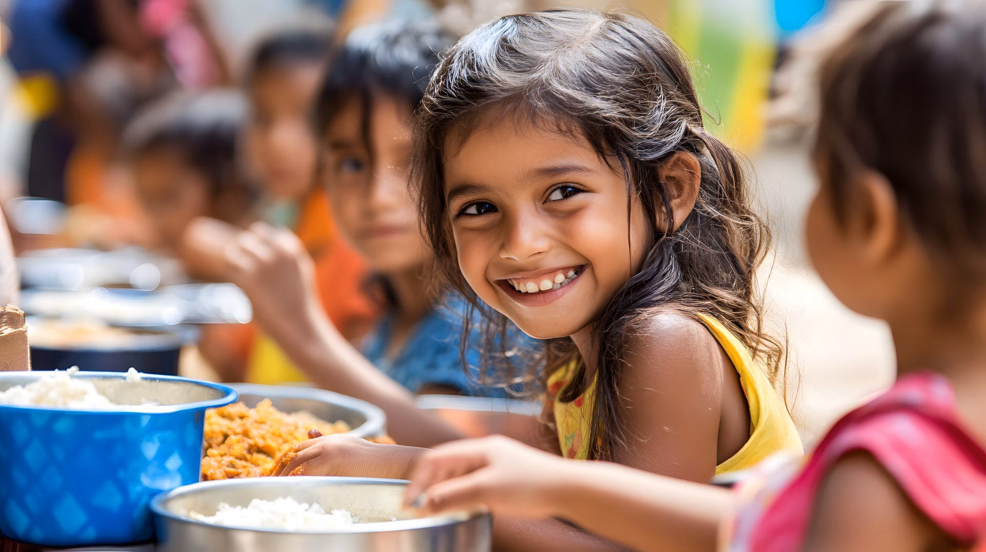 Smiling child enjoying a meal with other kids, symbolizing happiness, charity, food donation, social welfare, poverty relief, community support, and kindness towards underprivileged children